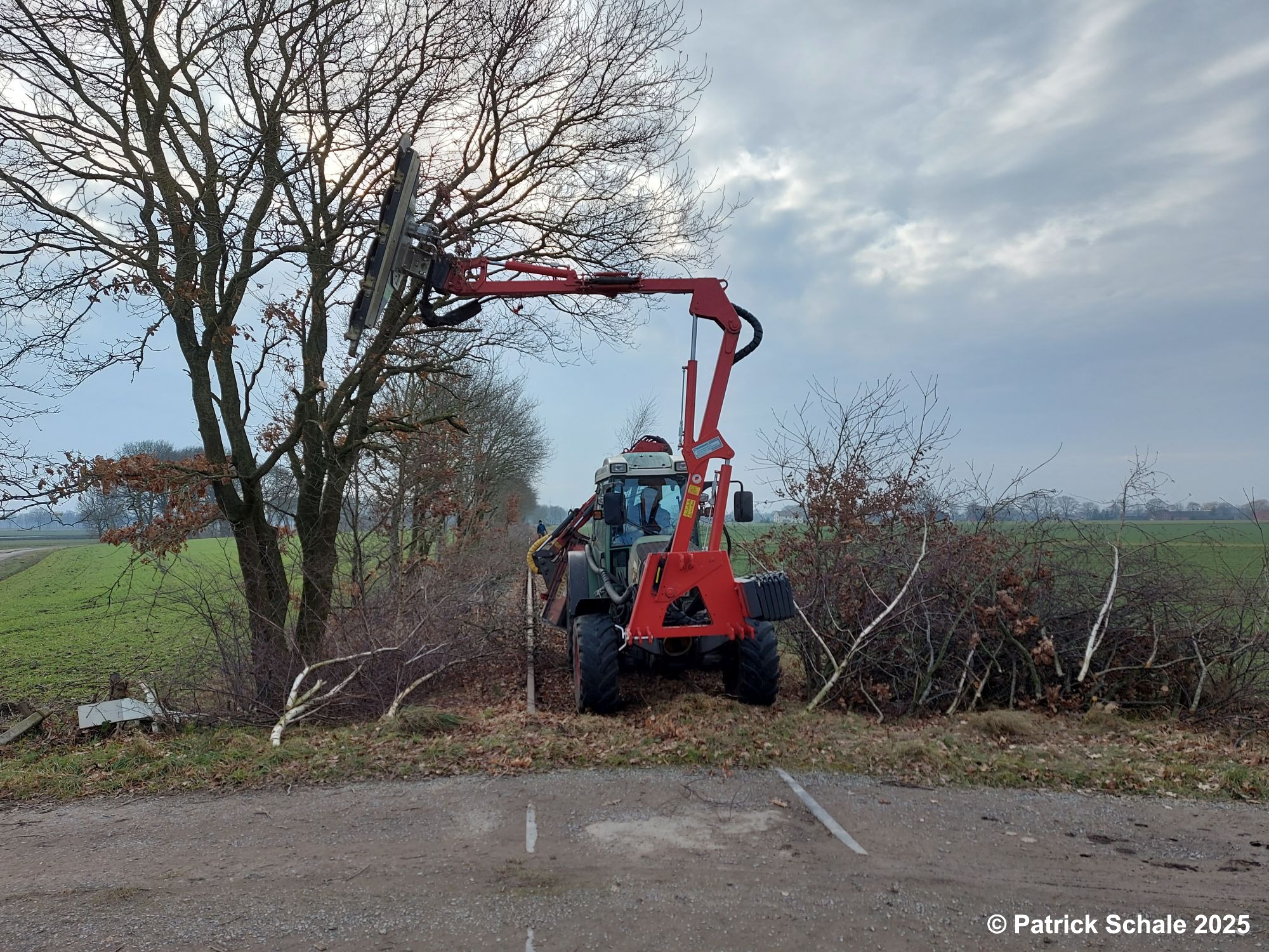 Freischnitt der Bahnstrecke im Bereich Varrel mit einem Trecker, der mit einem Anbaugerät mit Sägeblättern ausgestattet ist
