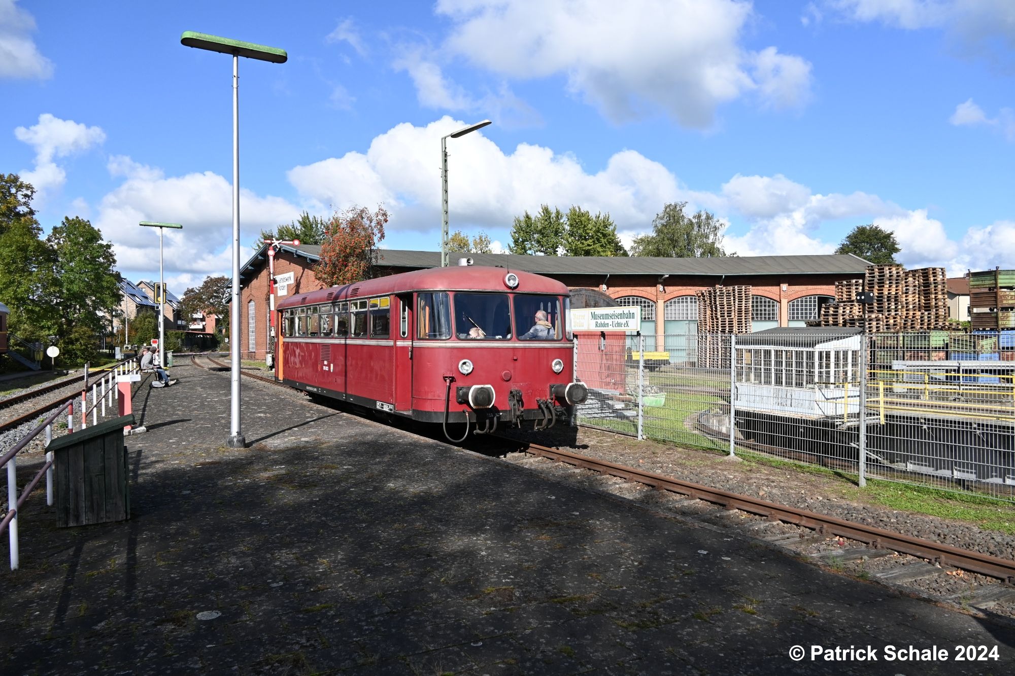 Schienenbus der Museumseisenbahn Rahden-Uchte e.V. am Bahnsteig in Rahden; im Hintergrund der Lokschuppen des ehemaligen Bahnbetriebswerks Rahden