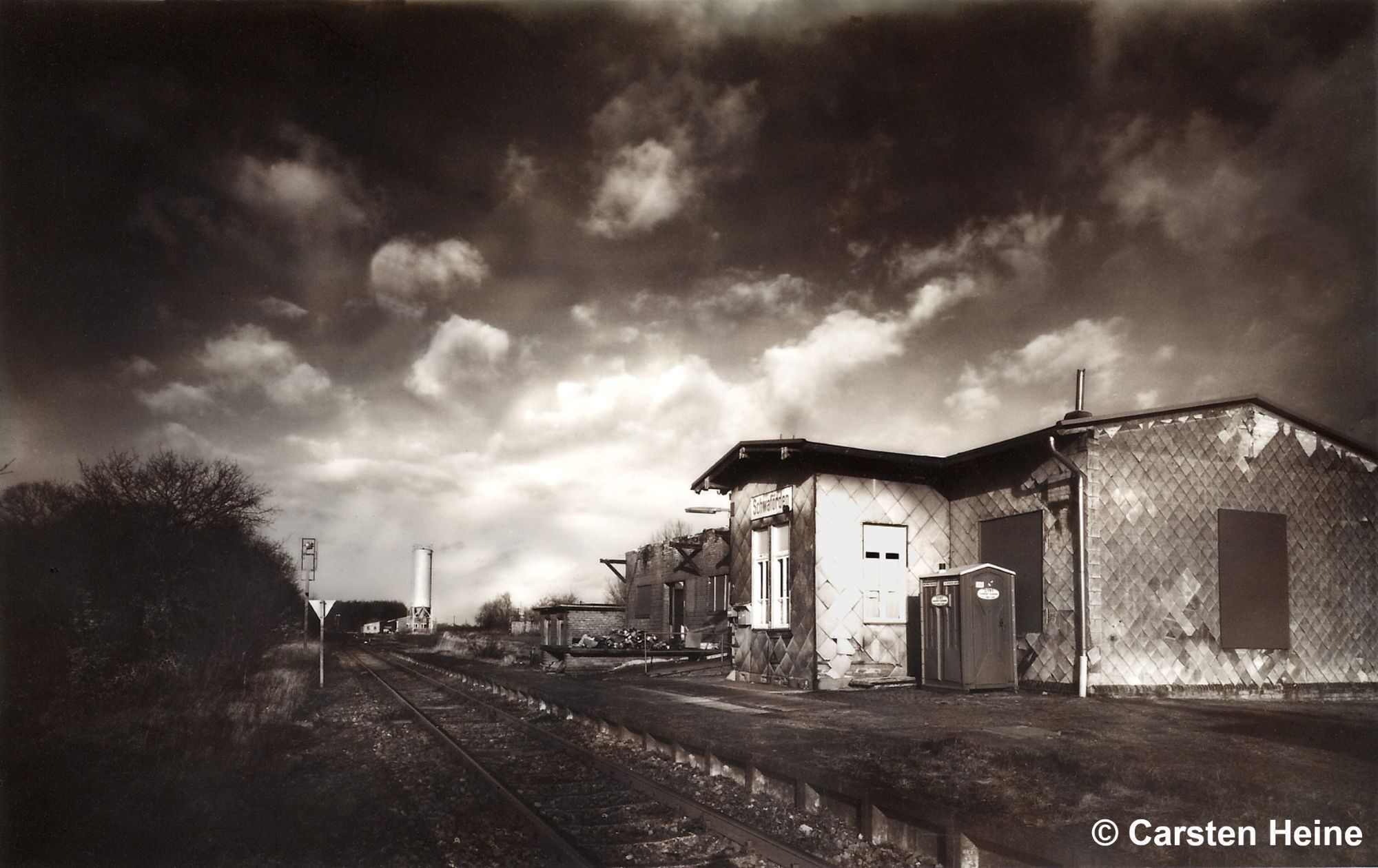 Bahnhofsgebäude Schwaförden von der Gleisseite aus gesehen; im Hintergrund der Güterschuppen und der Güterschuppen; vorne die Bahnsteigkante