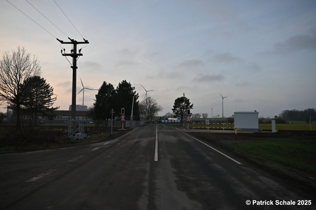 Erneuerter Bahnübergang mit neuen Lichtzeichenanlagen, Halbschranken und neuem Schalthäuschen am Schlaher Damm bei Sonnenuntergang