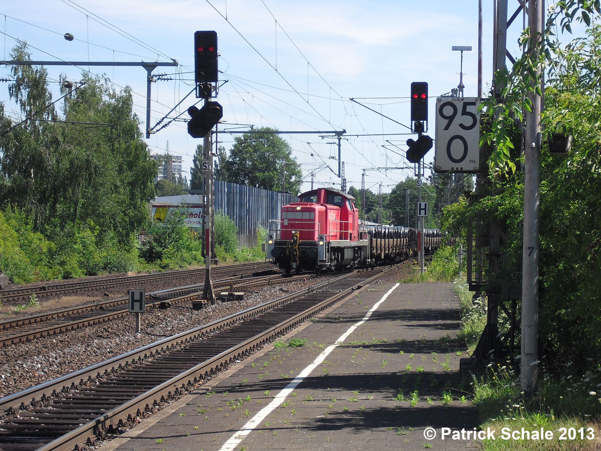 Güterzug mit roter Diesellok der DB Schenker Rail AG fährt aus einem Überholgleis aus, um die Hauptbahn in Richtung Lübbecke zu verlassen und dort den Gleisanschluss der BESTA Eisen- und Stahlhandelsgesellschaft mbH zu bedienen, links und rechts der Lokomotive befinden sich Hauptsignale