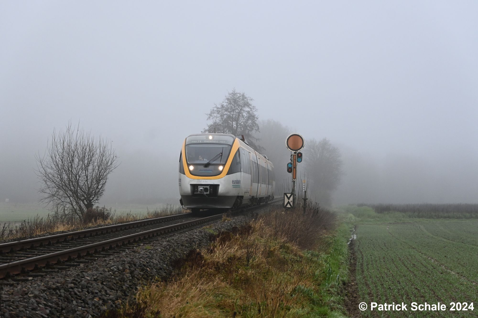 Dieseltriebwagen der Eurobahn auf dem Weg nach Bielefeld Hbf passiert an einem kalten und nebeligen Wintertag das südliche Einfahrvorsignal des Bahnhofs Bad Holzhausen