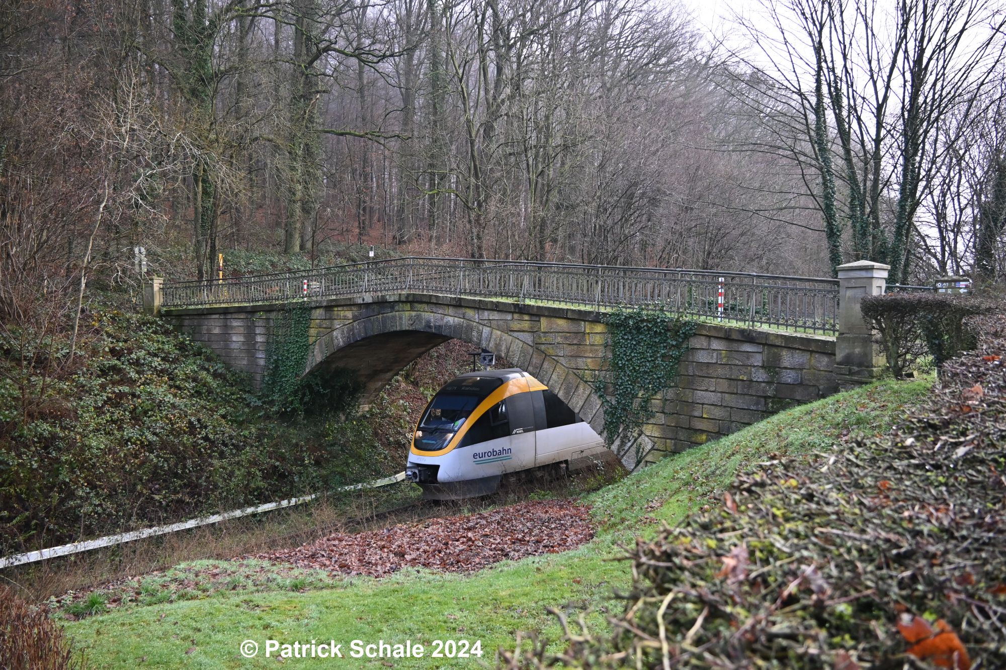 Triebwagen der Eurobahn nach Rahden passiert die Natursteinbrücke am Bedarfshaltepunkt Mesch Neue Mühle