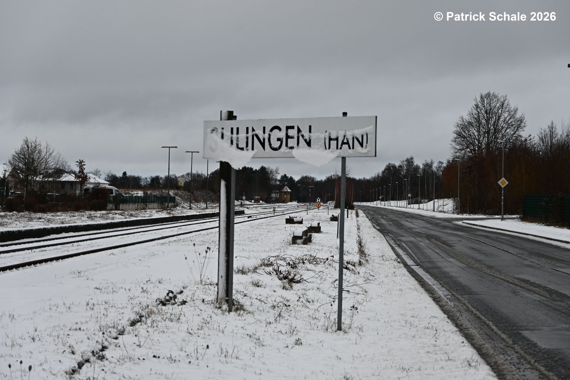 Eingeschneites Stationsschild Sulingen (Han), dahinter ein Bahnsteig und ganz hinten Stellwerk Sn