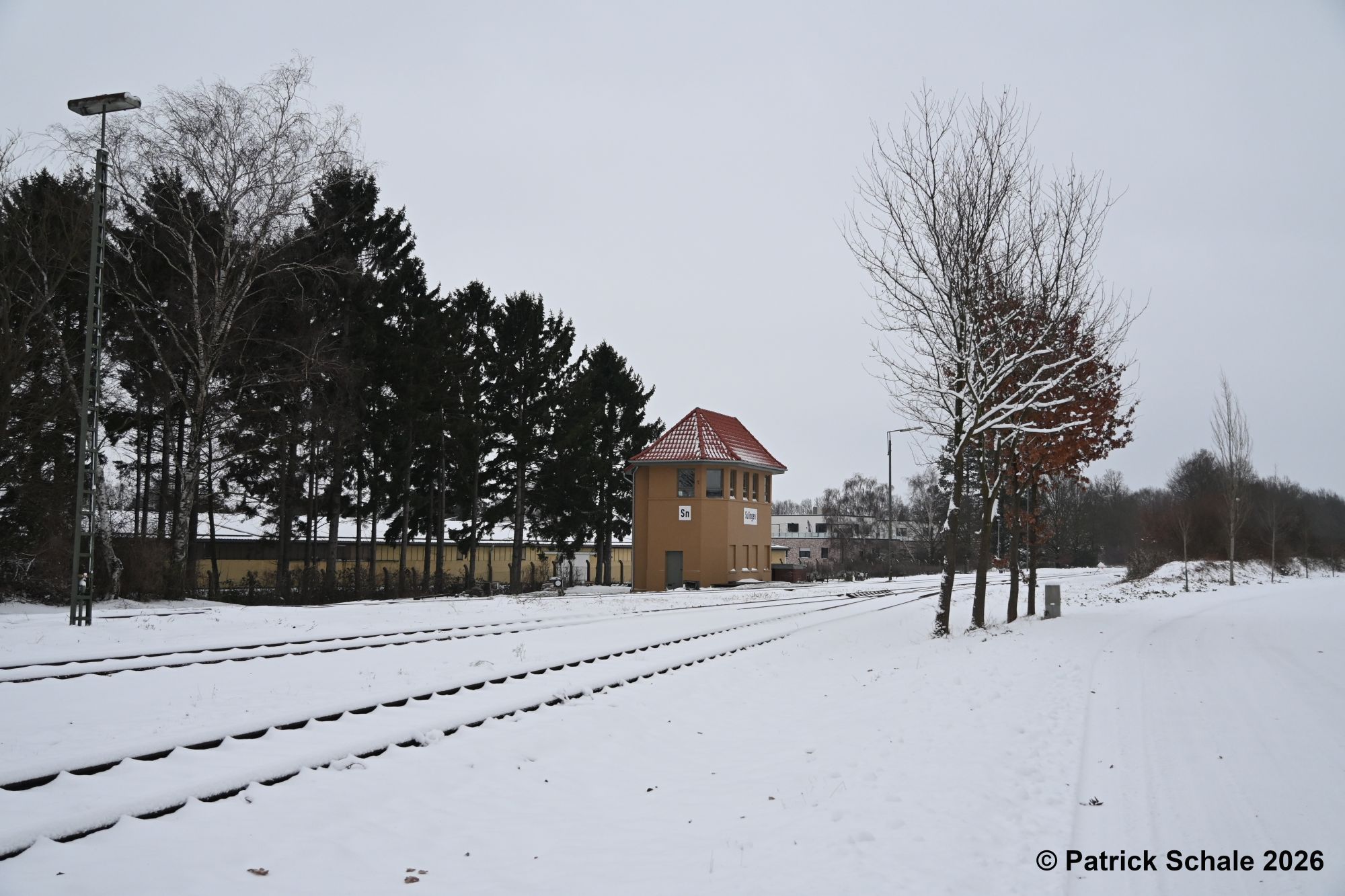 Stellwerk Sn im Schnee, links eine Lampe der Gleisfeldbeleuchtung