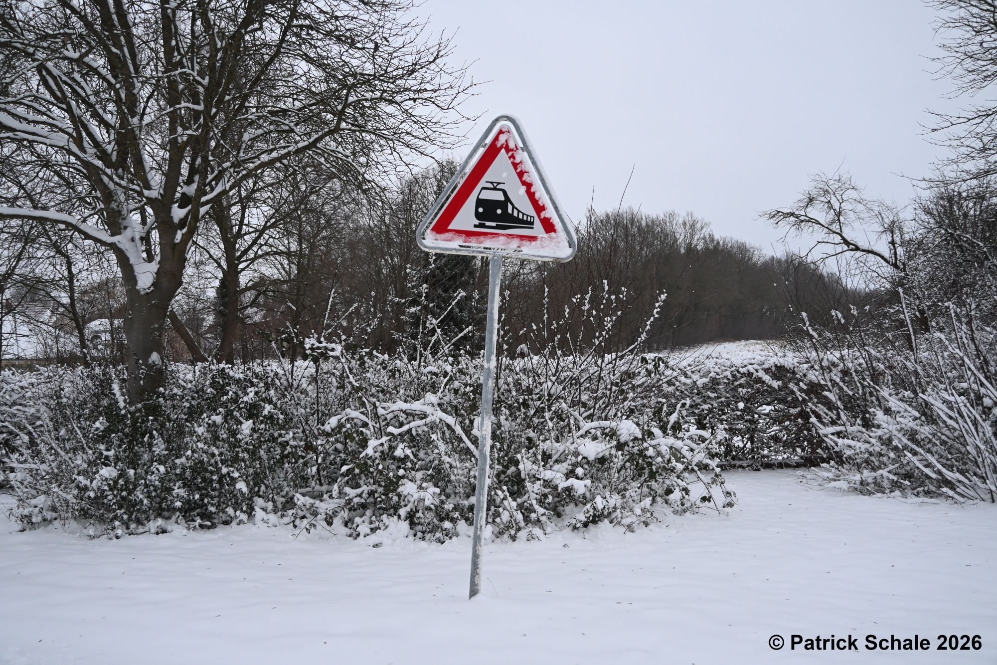 Eingeschneites Gefahrenzeichen Bahnübergang