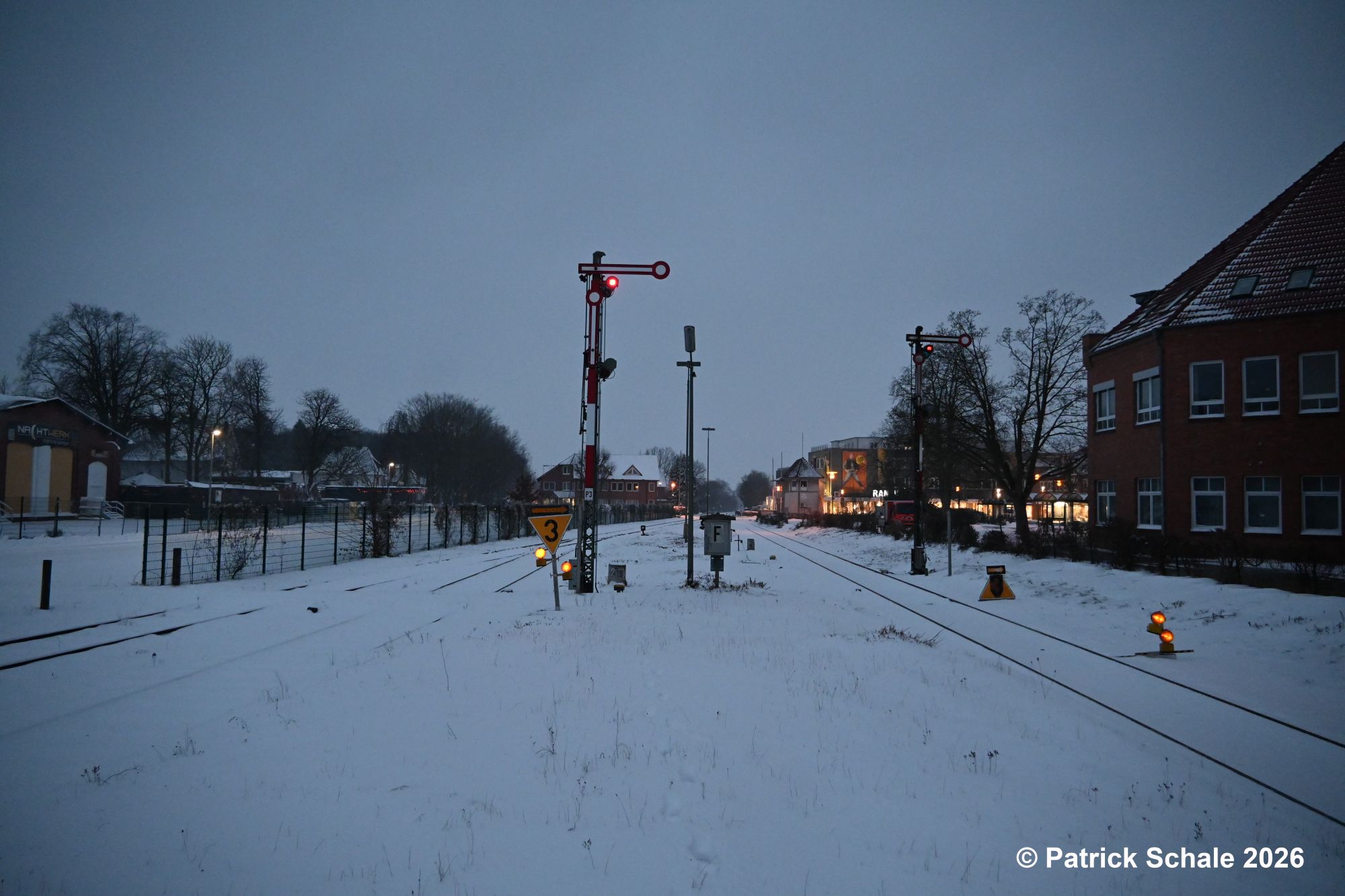 Blick vom Bahnsteig auf die südlichen Ausfahrsignale, einen Fernsprechkasten und Ankündigungssignale für eine Langsamfahrstelle mit einer Geschwindigkeitsbegrenzung auf 30 km/h