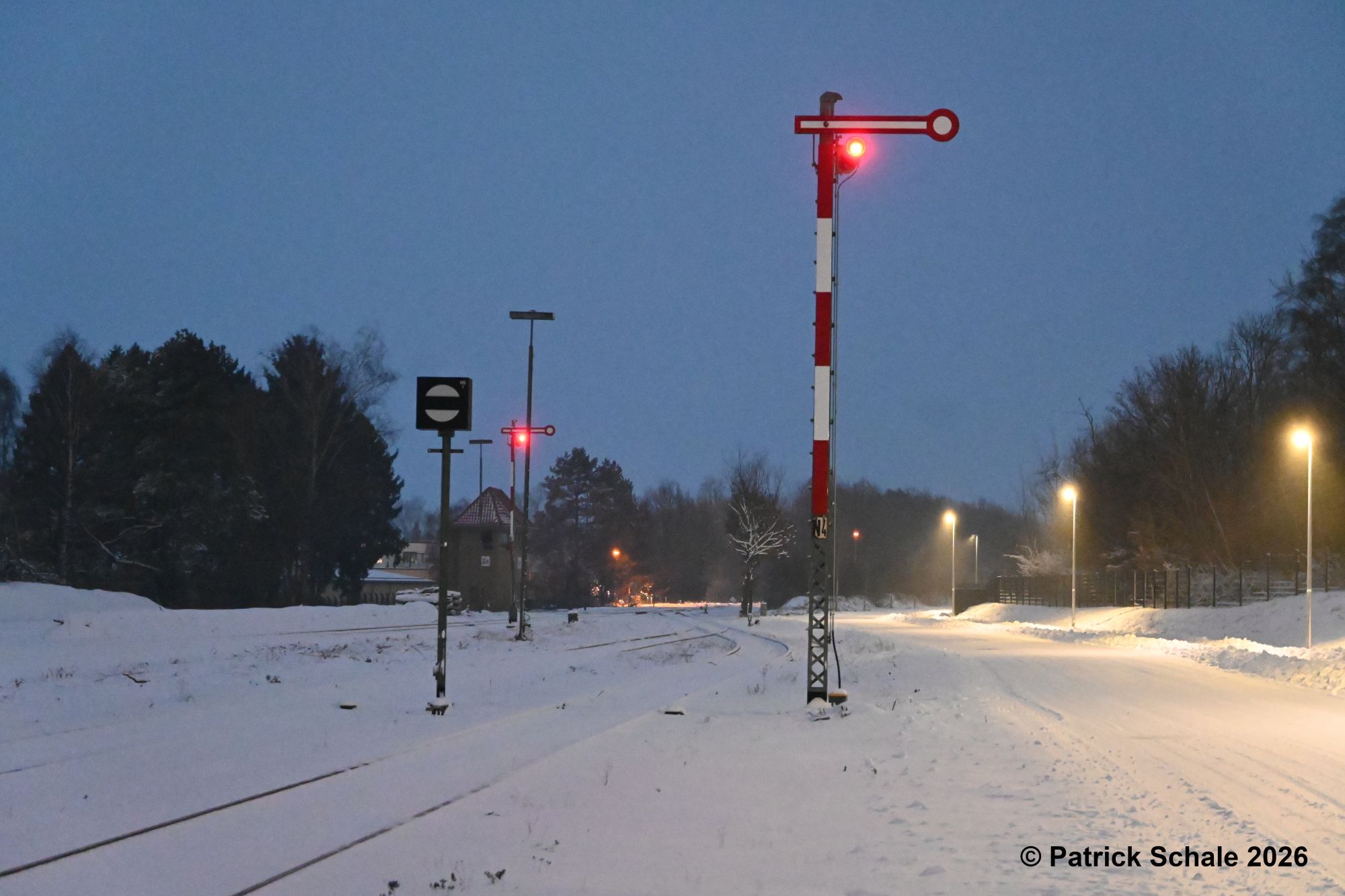 Zielsignale im Nordkopf des Bahnhofs Sulingen in Stellung HP 0, Halt, und Gleissperrsignal in Stellung Sh 0, Rangierhalt, links im Hintergrund Stellwerk Sn