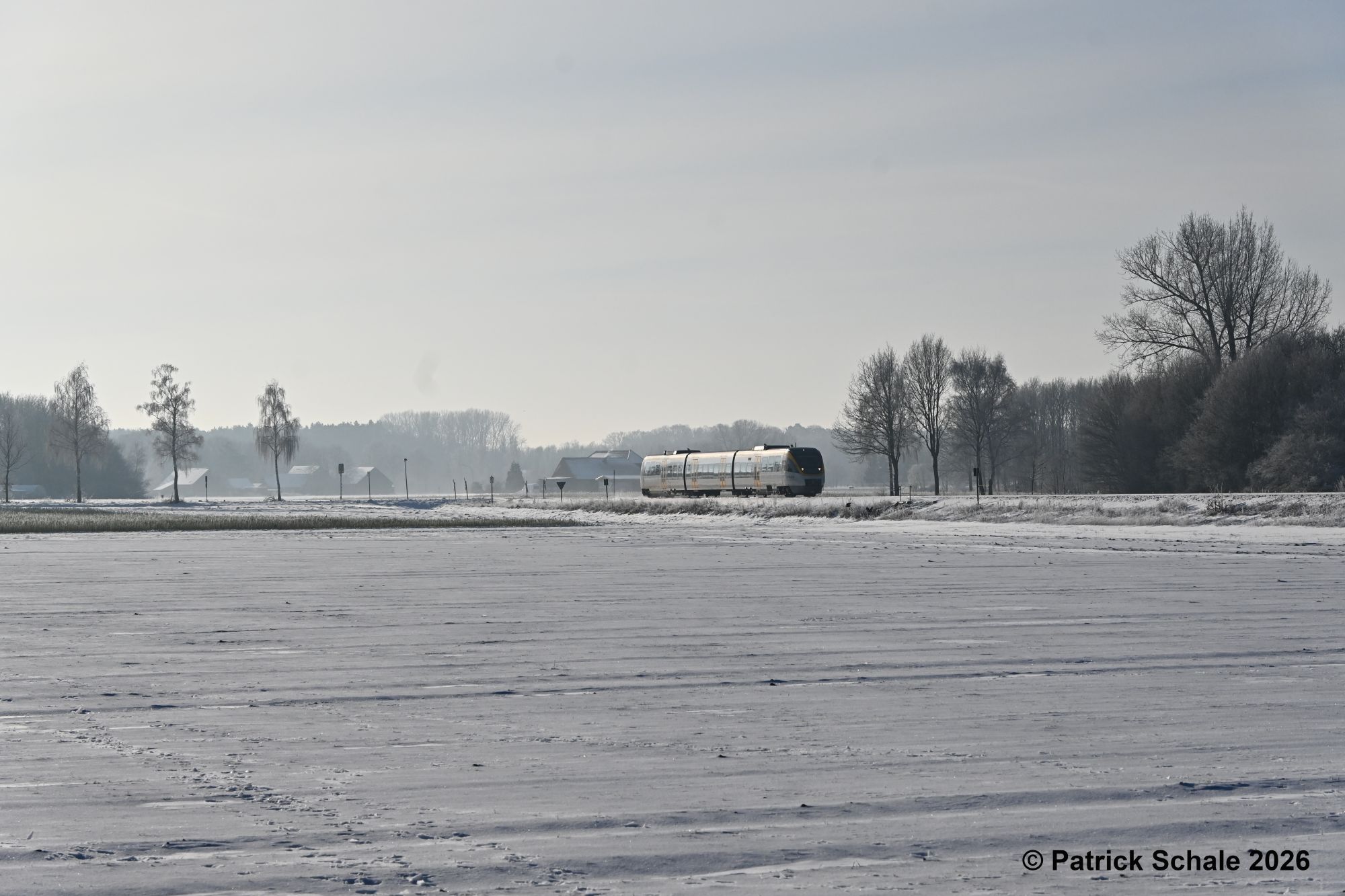 RB 71 nach Rahden kurz vor dem Erreichen seines Zielbahnhofs zwischen zugeschneiten landwirtschaftlichen Flächen