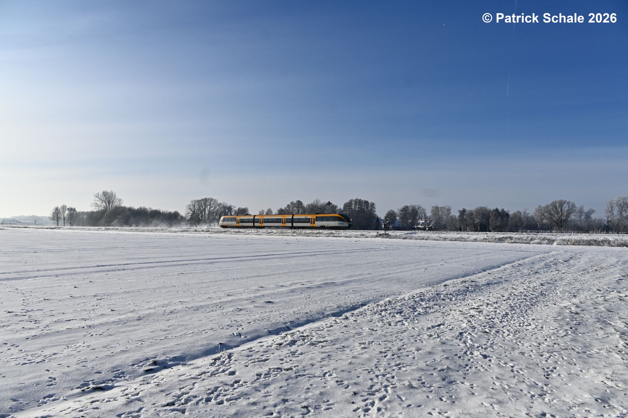 RB 71 nach Rahden kurz vor dem Erreichen seines Zielbahnhofs zwischen zugeschneiten landwirtschaftlichen Flächen