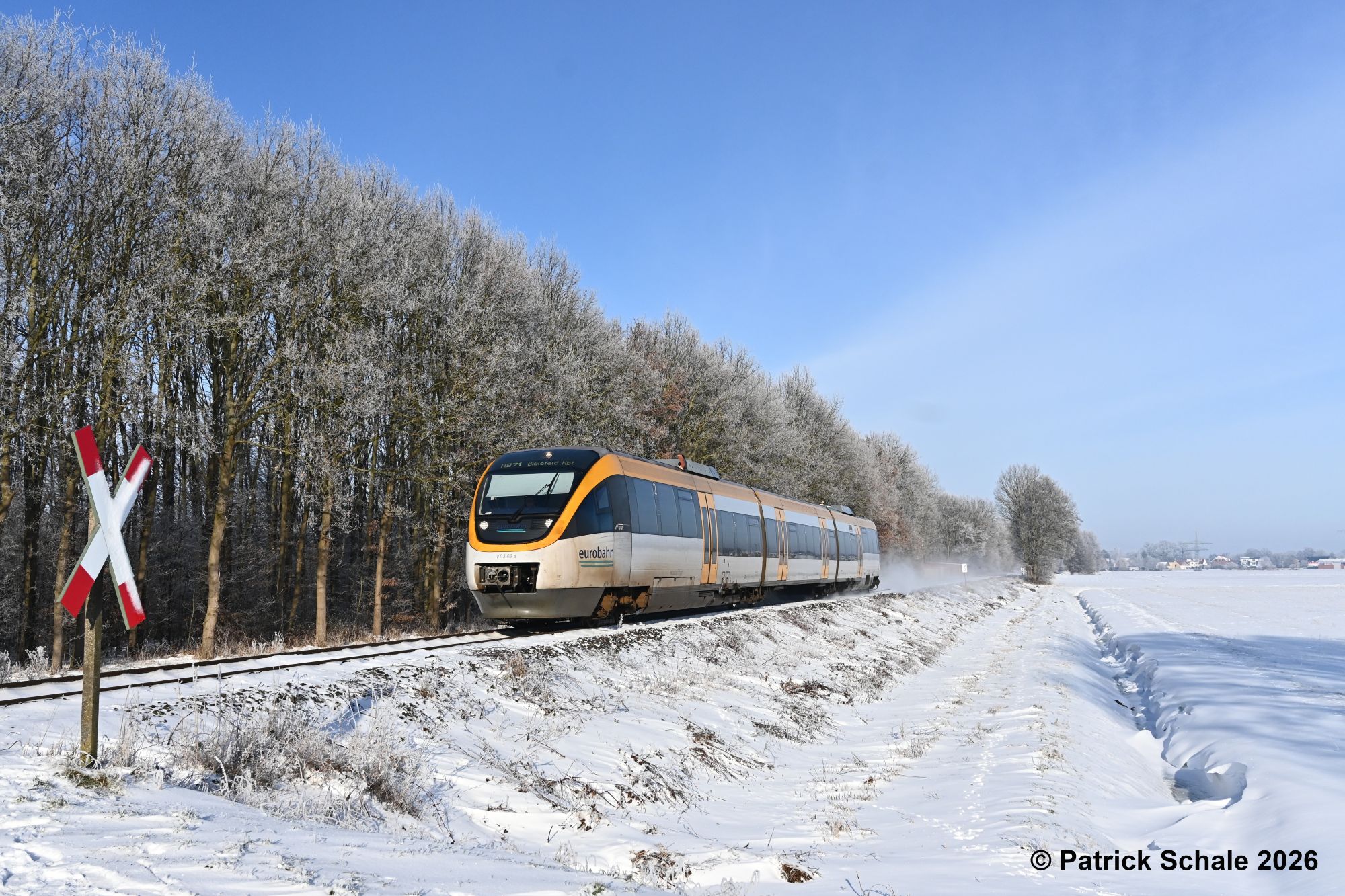Winter in Ostwestfalen: Triebwagen der Eurobahn als RB 71 von Rahden nach Bielefeld Hbf an einem nicht-technisch gesicherten Bahnübergang