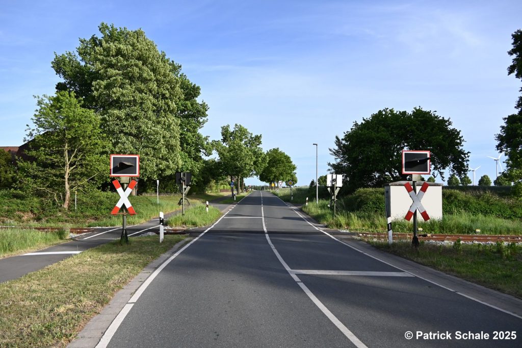 Bahnübergang mit Blinklichtern in Groß Lessen, links Fuß- und Fahrradweg, Blickrichtung B 214 (Grafitti auf Schalthäuschen entfernt)