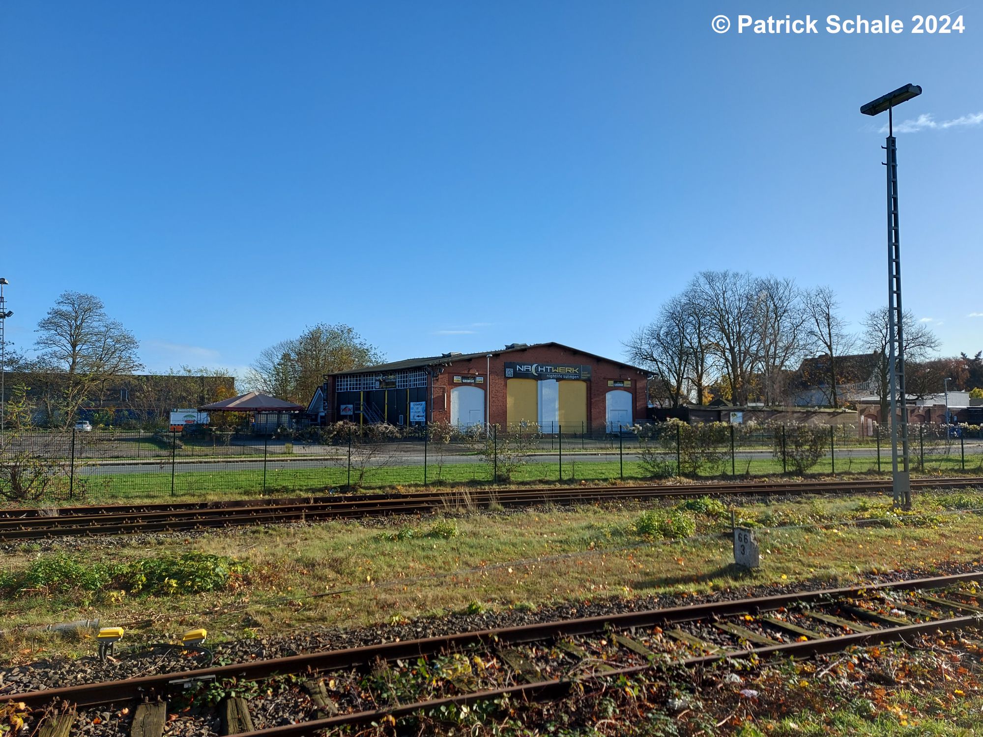 Blick über die Gleise 2 - 4 zum Lokomotivschuppen, zuletzt Diskothek Nachtwerk, im Vordergrund neben den Gleisen 2 - 4 ein Kilometerstein mit der Inschrift 66,3 sowie eine Lampe der Gleisfeldbeleuchtung