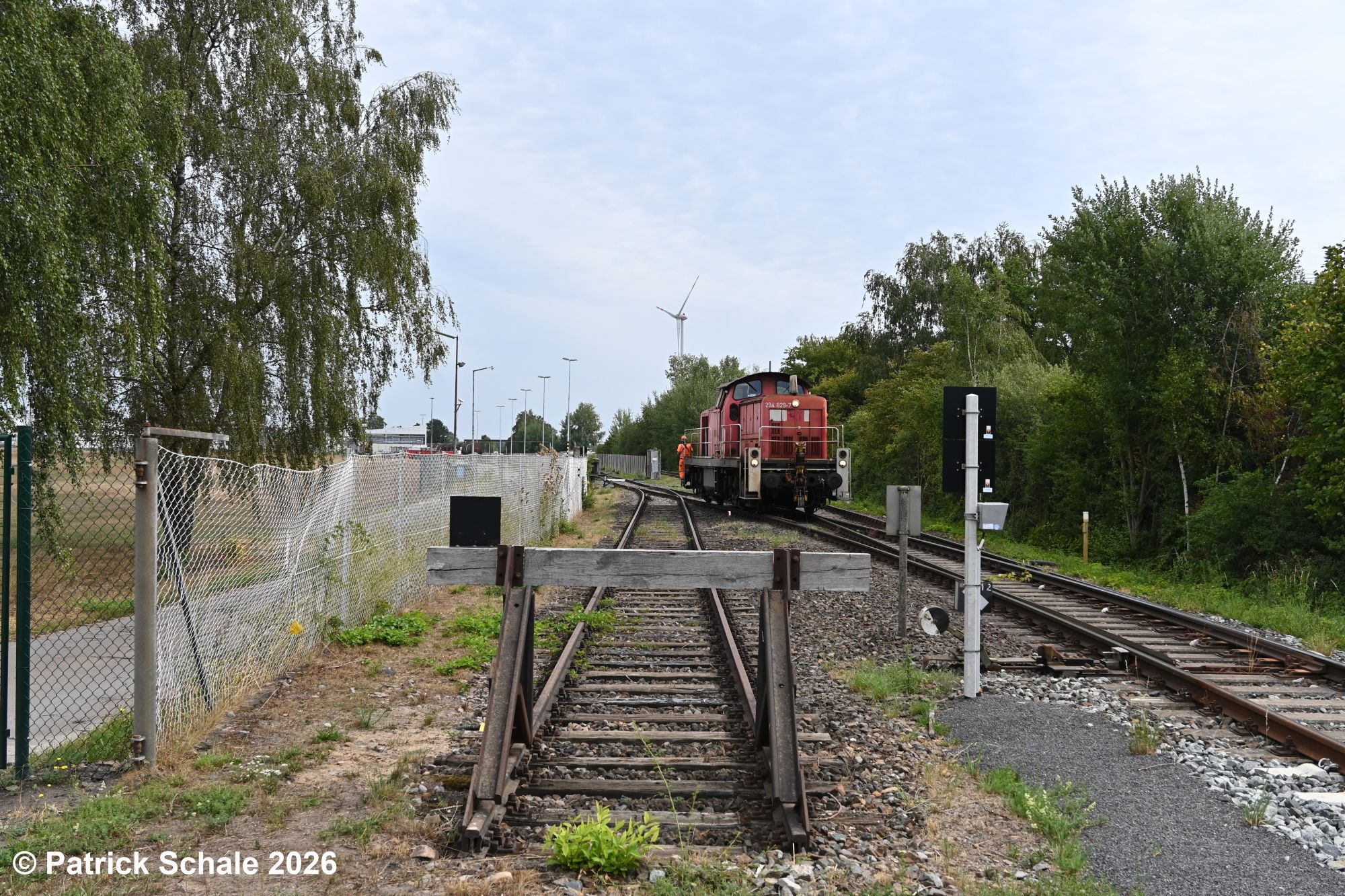 Bedienung des Werkes von ExxonMobil in Barenburg: Die Diesellokomotive rollt in das Werk, um mit rohölbeladene Kesselwagen abzuholen. Im Vordergrund ist ein Prellbock zu sehen, der das Gleis für den Flankenschutz abschließt.