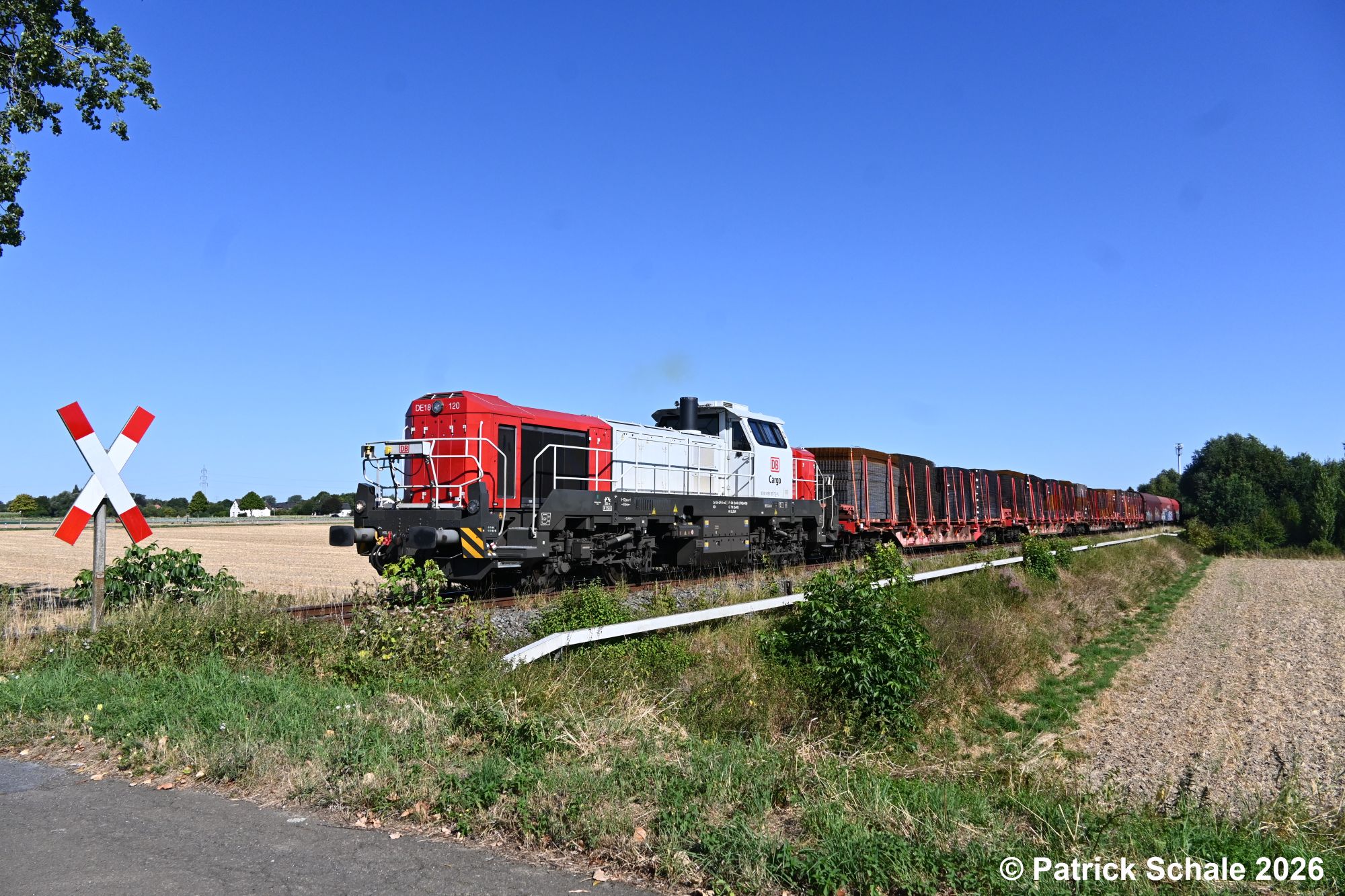 Nach der Bedienung des Gleisanschlusses Lübbecke (Westf) BESTA rollt der Güterzug mit diversen Stahlerzeugnissen Richtung Süden und passiert den Bahnübergang Rampenweg.