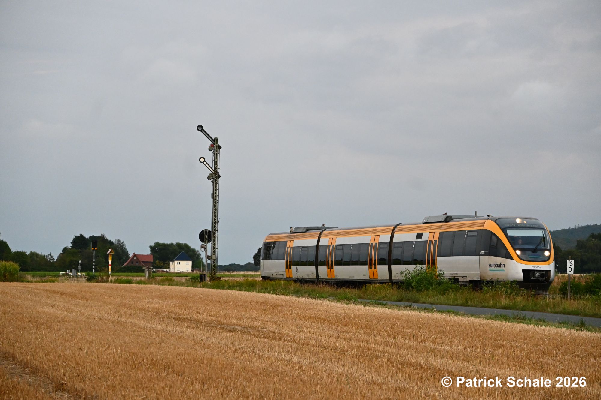 Die RB 71 nach Bielefeld Hbf hat Einfahrt auf HP 2 Langsamfahrt und Vr 0 Halt erwarten in den Bahnhof Bad Holzhausen und passiert ein abgeerntetes Getreidefeld