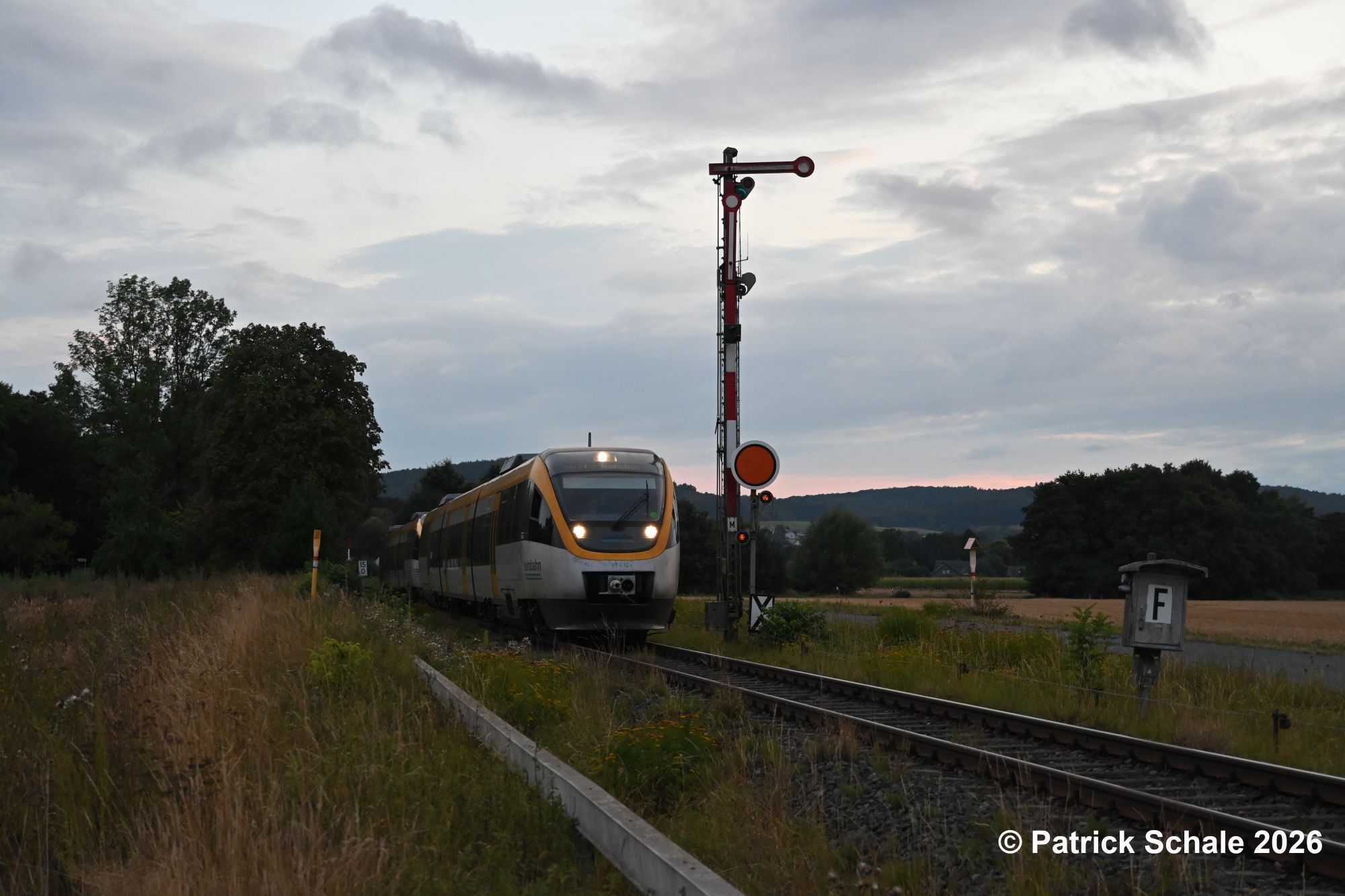 Die RB 71 nach Rahden verlässt im letzten Lichtt den Bahnhof Bad Holzhausen und passiert das Einfahrsignal, Ausfahrvorsignal und einen Fernsprechkasten. Nächster Halt ist dann Lübbecke in Westfalen.